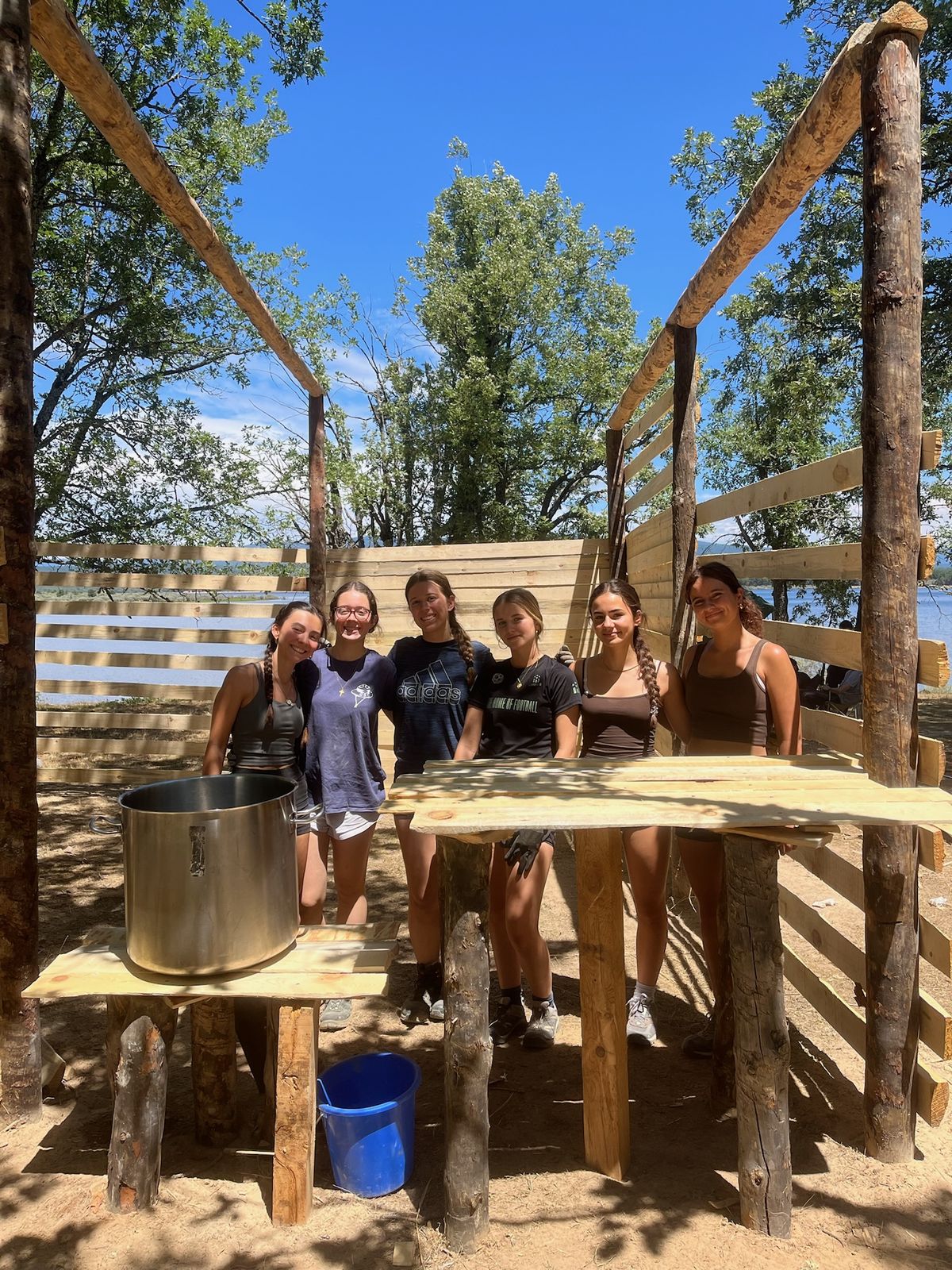Monitoras construyendo el rincón de cocina en el campamento