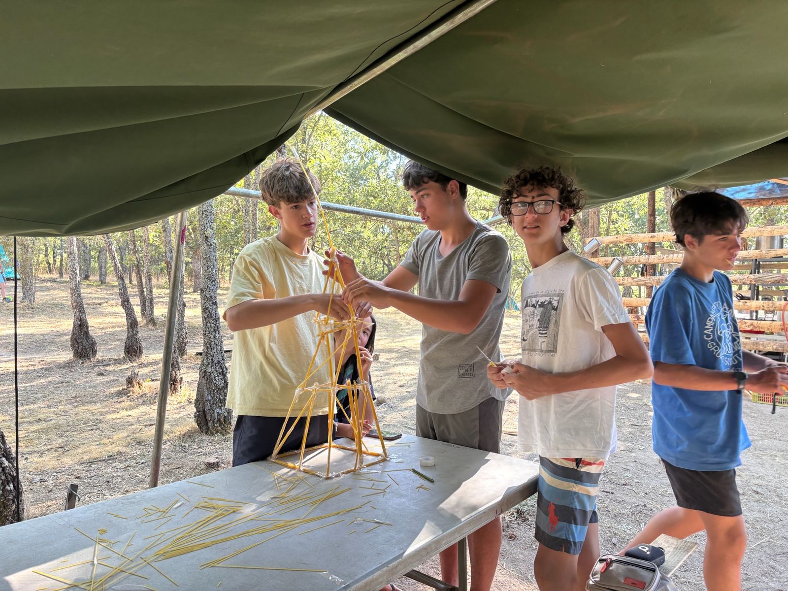 Scouts construyendo una torre de espaguetis en un taller