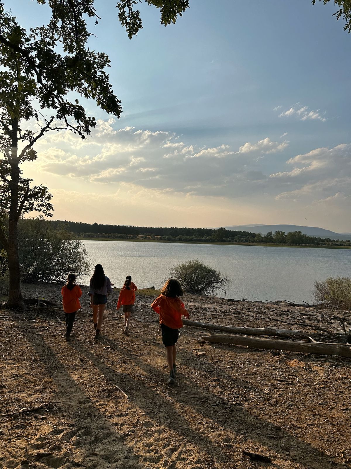 Scouts caminando junto al lago al atardecer